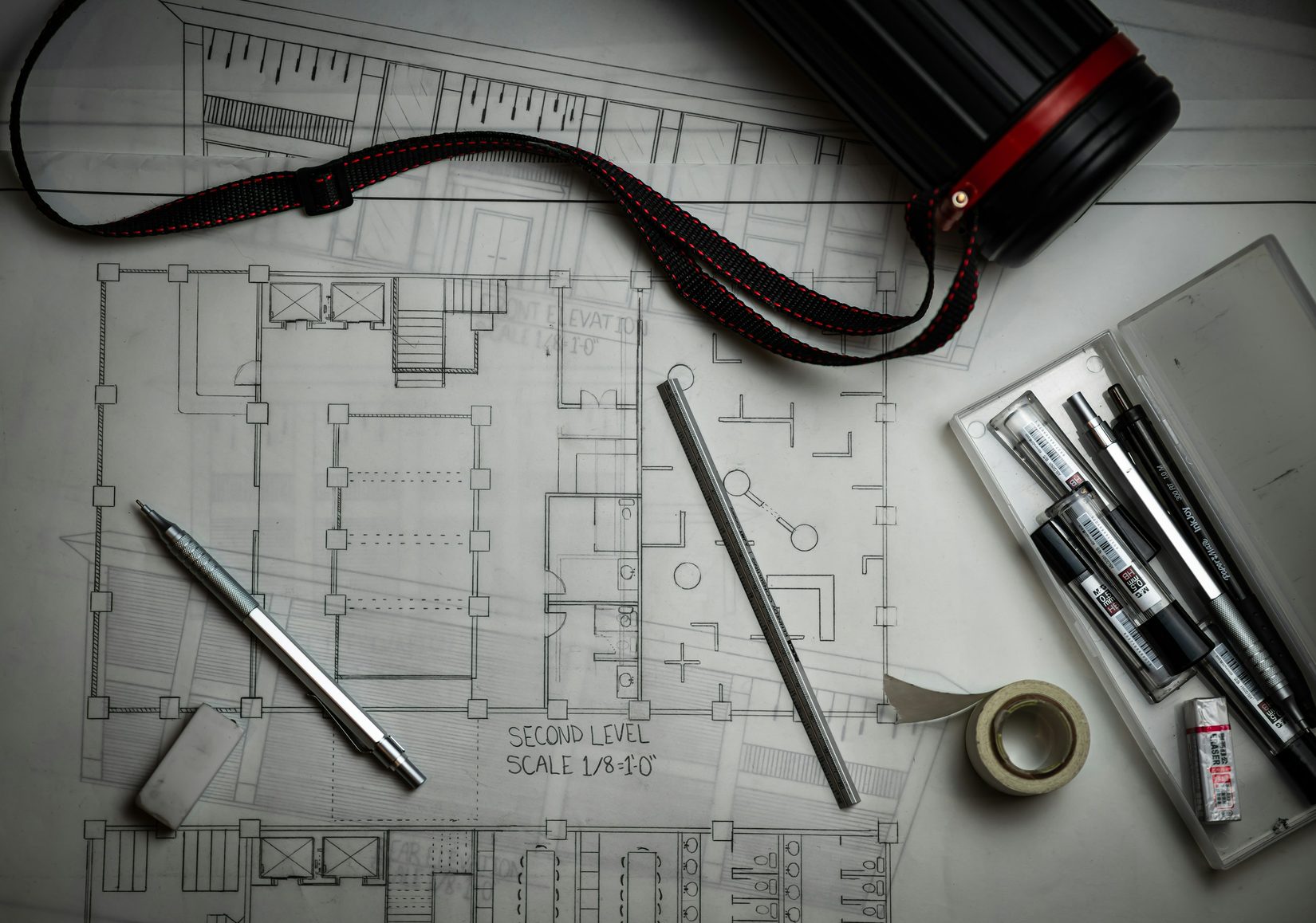 Architectural blueprints with drafting pencils and a metal r Architectural blueprints with drafting pencils and a metal rule