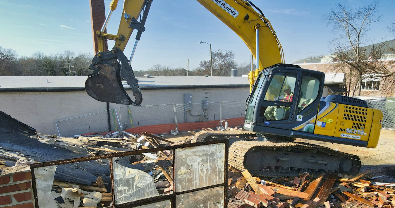 Excavator clearing demolished brickwork Excavator clearing demolished brickwork