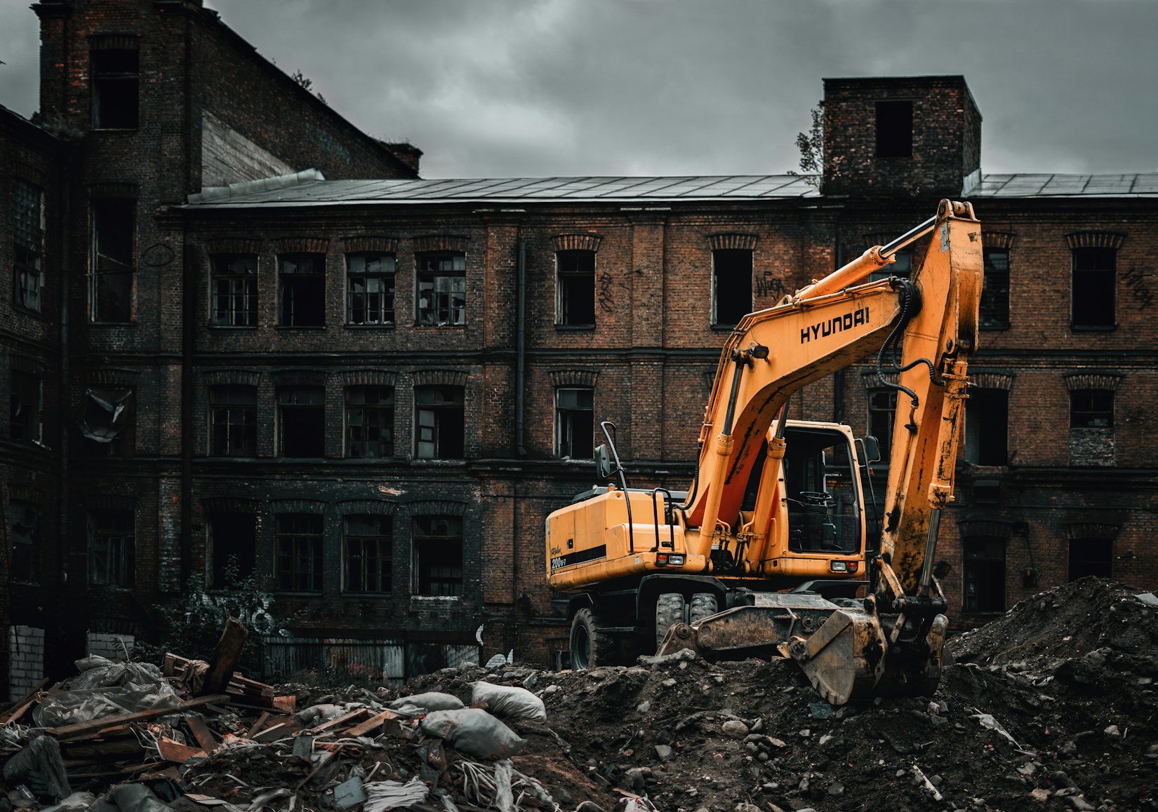 Excavator demolishing a brick building Excavator demolishing a brick building
