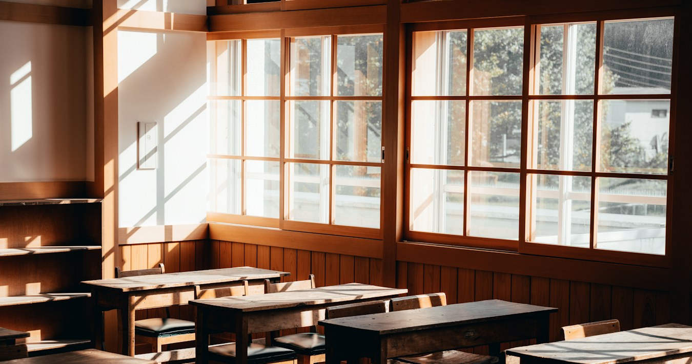 Classroom with timber desks and large windows Classroom with timber desks and large windows